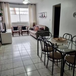 - un salon avec une table, des chaises et un canapé dans l'établissement Apartamento quadra da praia - Pitangueiras Guarujá, à Guarujá
