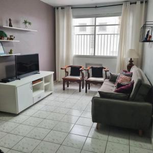 - un salon avec un canapé et une télévision dans l'établissement Apartamento quadra da praia - Pitangueiras Guarujá, à Guarujá