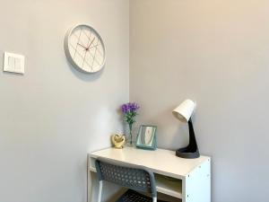 un escritorio con una lámpara y un reloj en la pared en MMRent Blue Lagoon Room, en Gdansk