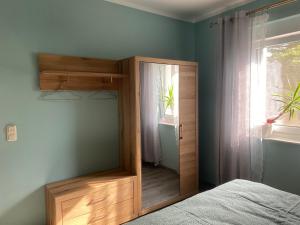 1 dormitorio con espejo junto a la cama en Ferienhaus Albertus en Cottbus