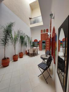ein großes Zimmer mit Tischen, Stühlen und Topfpflanzen in der Unterkunft Riad Maya in Rabat