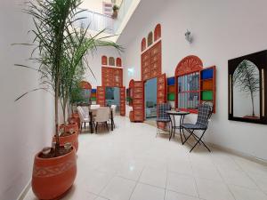 a dining room with a table and a potted plant at Dar Maya in Rabat