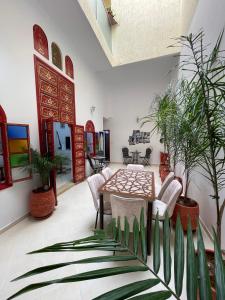 ein Esszimmer mit einem Tisch, Stühlen und Pflanzen in der Unterkunft Riad Maya in Rabat
