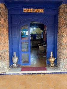 - une entrée bleue pour un café avec une porte bleue dans l'établissement AMRAOUI Apartment, à Moulay Ali Chérif
