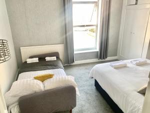 a bedroom with two beds and a window at Lovely city town house with free parking sleeps 2 to 6 guests in York