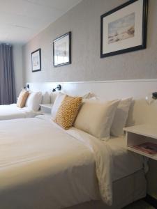 San Marco Hotel Curacao & Casino في فيليمستاد: غرفة في الفندق بسريرين مع وسائد بيضاء