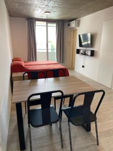 Zimmer mit einem Tisch, 2 Stühlen und einem Bett in der Unterkunft monoambiente rosario zona pichincha in Rosario