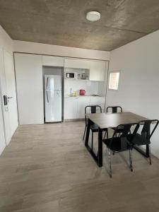 ein Esszimmer mit einem Tisch und Stühlen sowie einem Kühlschrank in der Unterkunft monoambiente rosario zona pichincha in Rosario