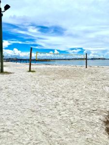 a volleyball net on a sandy beach with the ocean at Lovely vacation home 1 block from beach & downtown Gulfport in St. Petersburg