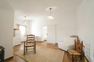 uma sala de estar com cadeiras de madeira e um sofá em Quinta do Freixo em Elvas