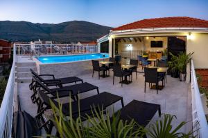 a patio with tables and chairs and a pool at Apartments Sweet Dreams in Trebinje