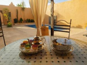 un tavolo con vassoio di cupcake e un bollitore per il tè di Villa brek a Marrakech