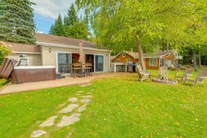 a yard with a deck with chairs and a tree at Kalkaska Retreat Private Hot Tub, Dock, Fireplace in Kalkaska