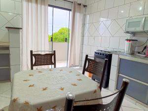 a kitchen with a table and a table and a stove at Lindo Apto102 em Primavera do Leste in Primavera do Leste