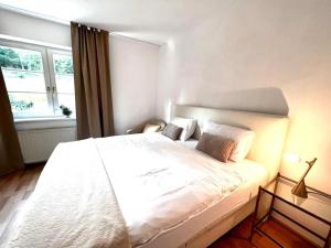 a white bed in a room with a window at Green House bei Baden 