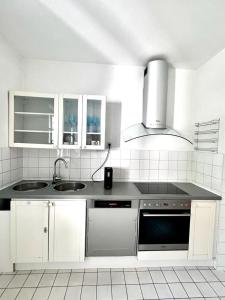 uma cozinha branca com um lavatório e um fogão em Green House bei Baden 