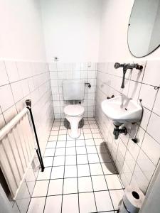 a white bathroom with a toilet and a sink at Green House bei Baden 