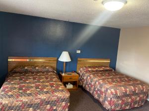 - 2 lits dans une chambre d'hôtel aux murs bleus dans l'établissement The Village Motel, à Steamboat Rock