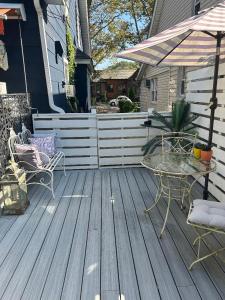 a patio with a table and chairs and an umbrella at Adorable 1 bedroom cottage in Forest Hills