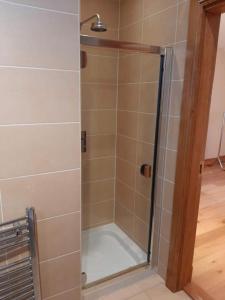 a shower with a glass door in a bathroom at The Lake House in Drumshanbo