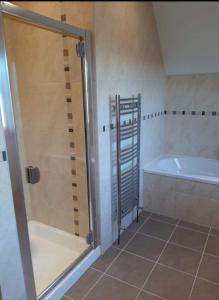 a bathroom with a shower and a bath tub at The Lake House in Drumshanbo
