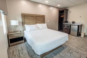 a bedroom with a white bed and a kitchen at Yellowstone Motel in Ipswich