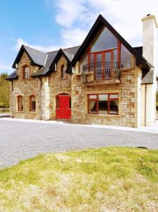a large brick house with a red door at The Lake House in Drumshanbo