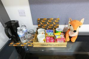 uma caixa de comida e uma raposa empalhada sentada num balcão em A102 Cheery Bright Loft em Coventry
