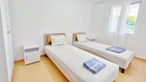 two beds in a small room with white walls at Green Moonlight in Ulcinj