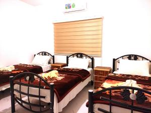 a room with three beds and two chairs at Majido Hotel in Wadi Musa
