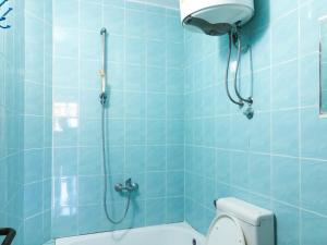W wyłożonej niebieskimi kafelkami łazience znajduje się toaleta i prysznic. w obiekcie Green Moonlight w Ulcinju