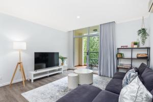 a living room with a couch and a tv at Royal Respite Spacious Apartment - Walk to Restaurants in Perth