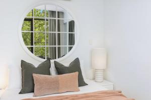 a white bedroom with a mirror and pillows on a bed at Royal Respite Spacious Apartment - Walk to Restaurants in Perth +20 photos