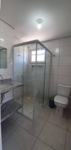 a bathroom with a glass shower and a toilet at Recanto Vó Mônica in Palhoça