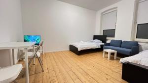 ein Wohnzimmer mit einem blauen Sofa und einem Bett in der Unterkunft Work&Stay - City nah in Neumünster