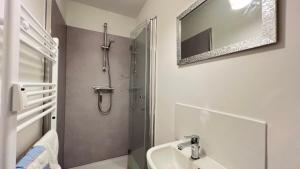ein Bad mit einer Dusche, einem Waschbecken und einem Spiegel in der Unterkunft Work&Stay - City nah in Neumünster
