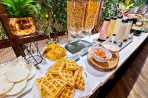 una mesa con gofres y otros alimentos. en GHL Hotel Portón Medellín, en Medellín