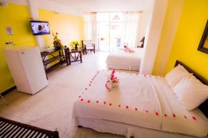 a large room with two beds and a refrigerator at Hotel Zihua Caracol in Zihuatanejo