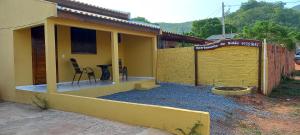 une maison jaune avec une table et une chaise à l'extérieur dans l'établissement Pousada do Sidão, à Estivado