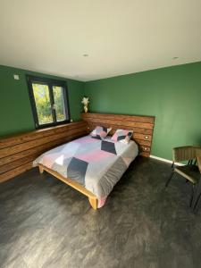 MontvernierにあるLe Cristal SPA Montvernierの緑の壁のベッドルーム1室(大型ベッド1台付)