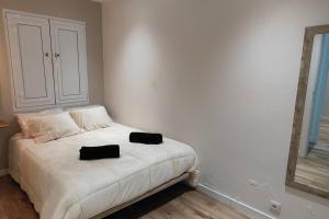 1 dormitorio con 1 cama con 2 almohadas negras en Azorina House, en Ponta Delgada