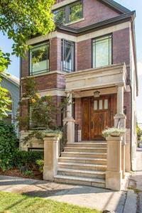 Casa de ladrillo con escaleras y puerta de madera en Featured in Chicago Socials Most Luxurious Airbnbs, en Chicago