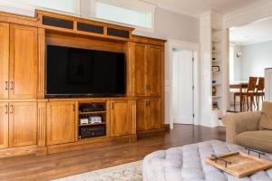 una sala de estar con un gran centro de entretenimiento de madera con TV en Featured in Chicago Socials Most Luxurious Airbnbs, en Chicago