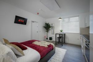 a bedroom with a bed with a clock on the wall at King Sized Luxury - Stylish Studio Flat in Blackpool