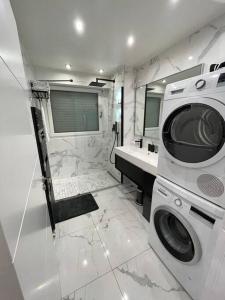 ein Badezimmer mit einer Waschmaschine und einem Waschbecken in der Unterkunft Appartement moderne de 2 pièces in Suresnes
