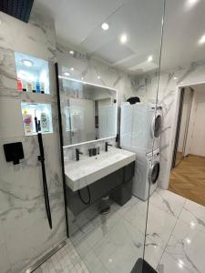 uma casa de banho branca com um lavatório e um chuveiro em Appartement moderne de 2 pièces em Suresnes