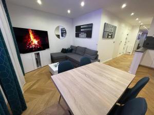uma sala de estar com uma mesa, um sofá e uma lareira em Appartement moderne de 2 pièces em Suresnes
