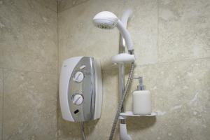 a shower in a bathroom with a phone on the wall at King Sized Luxury - Stylish Studio Flat in Blackpool