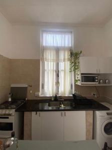 a kitchen with a sink and a window at Rivière Hostel in Cordoba
