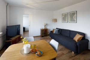 リガにあるBrivibas Yard Apartment With Parking In City Centerのテーブルと青いソファのあるリビングルーム